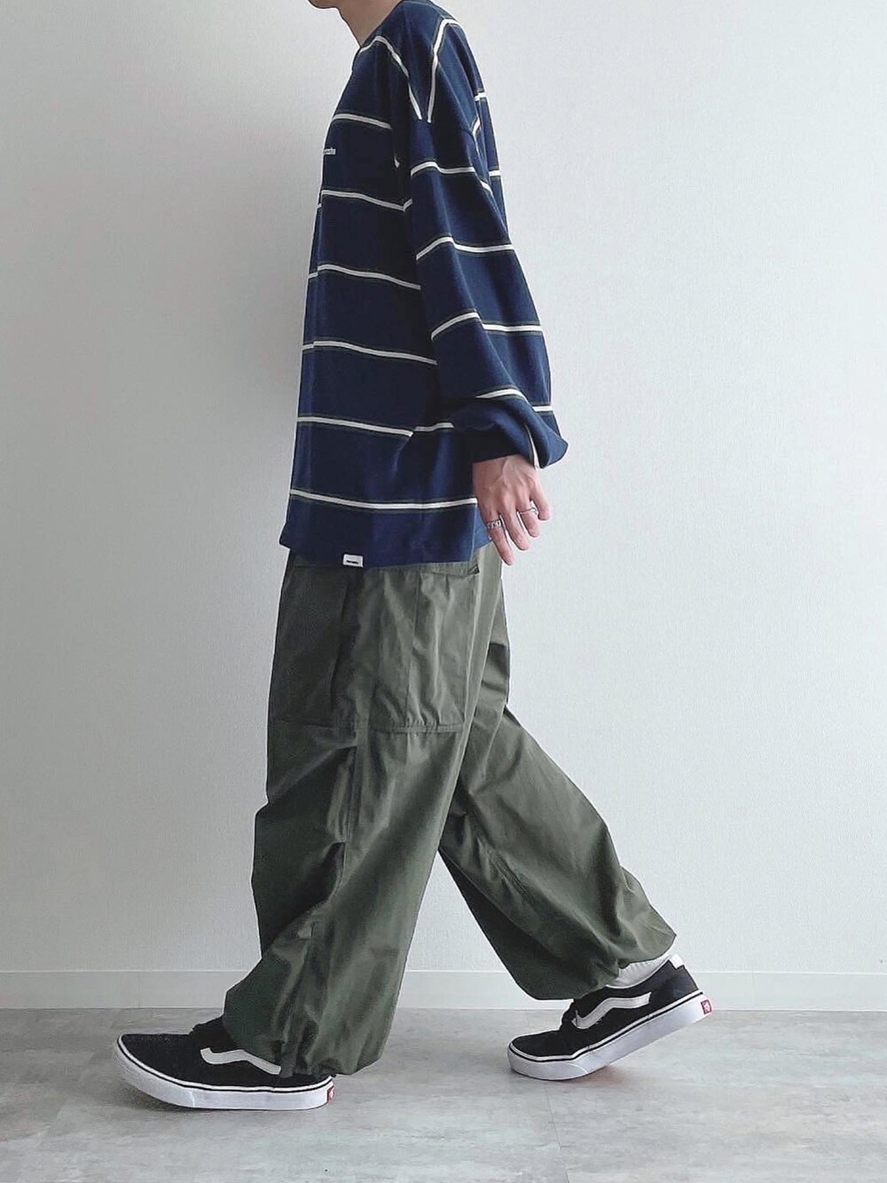 ブルー系のTシャツ/カットソー、グリーン系のカーゴパンツ、ブラック系のスニーカーを着用したメンズの秋コーディネートの3枚目の写真