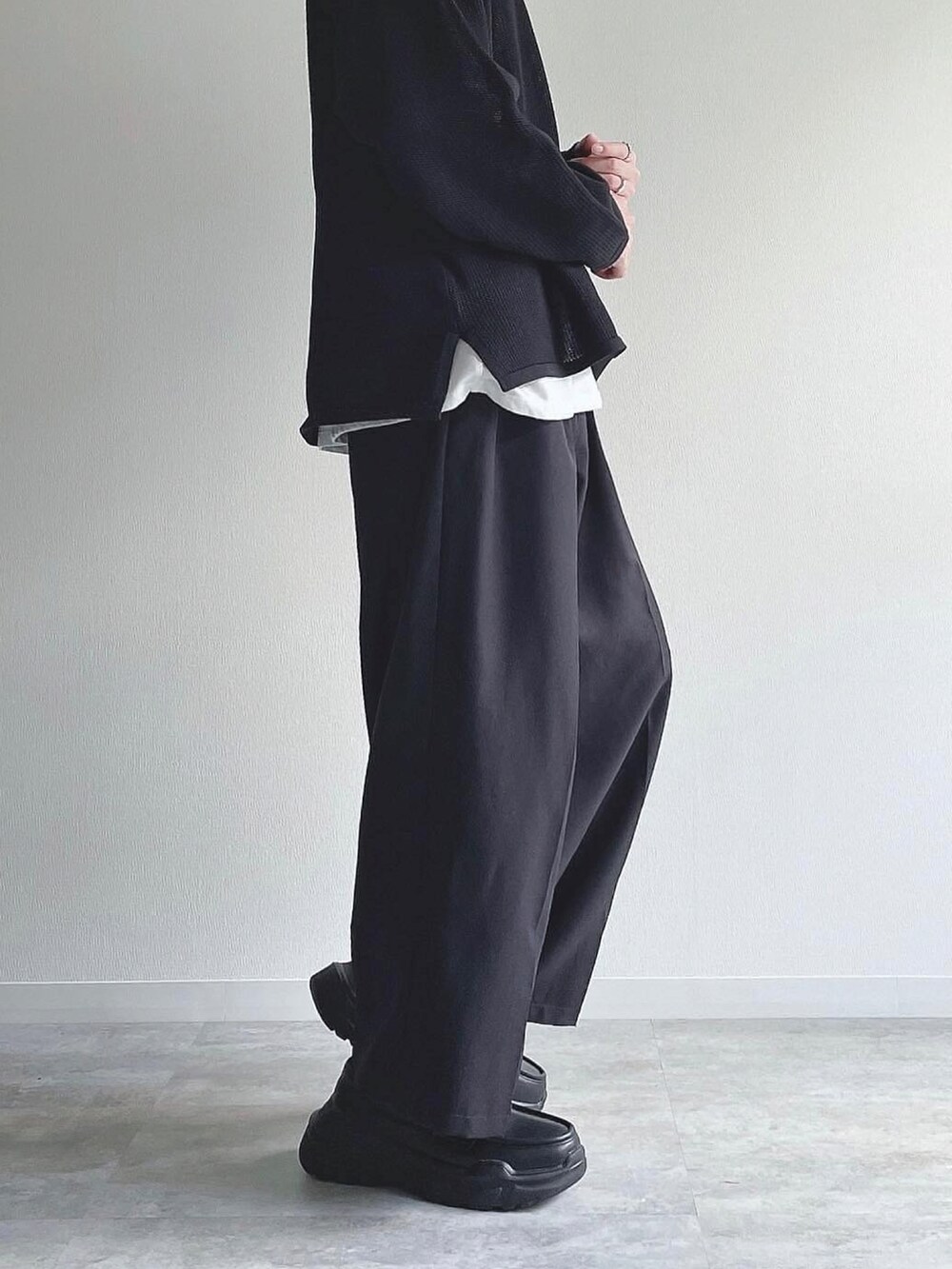 ブラック系のトップス、ブラック系のスラックス、ブラック系のスニーカーを着用したメンズの秋コーディネートの3枚目の写真