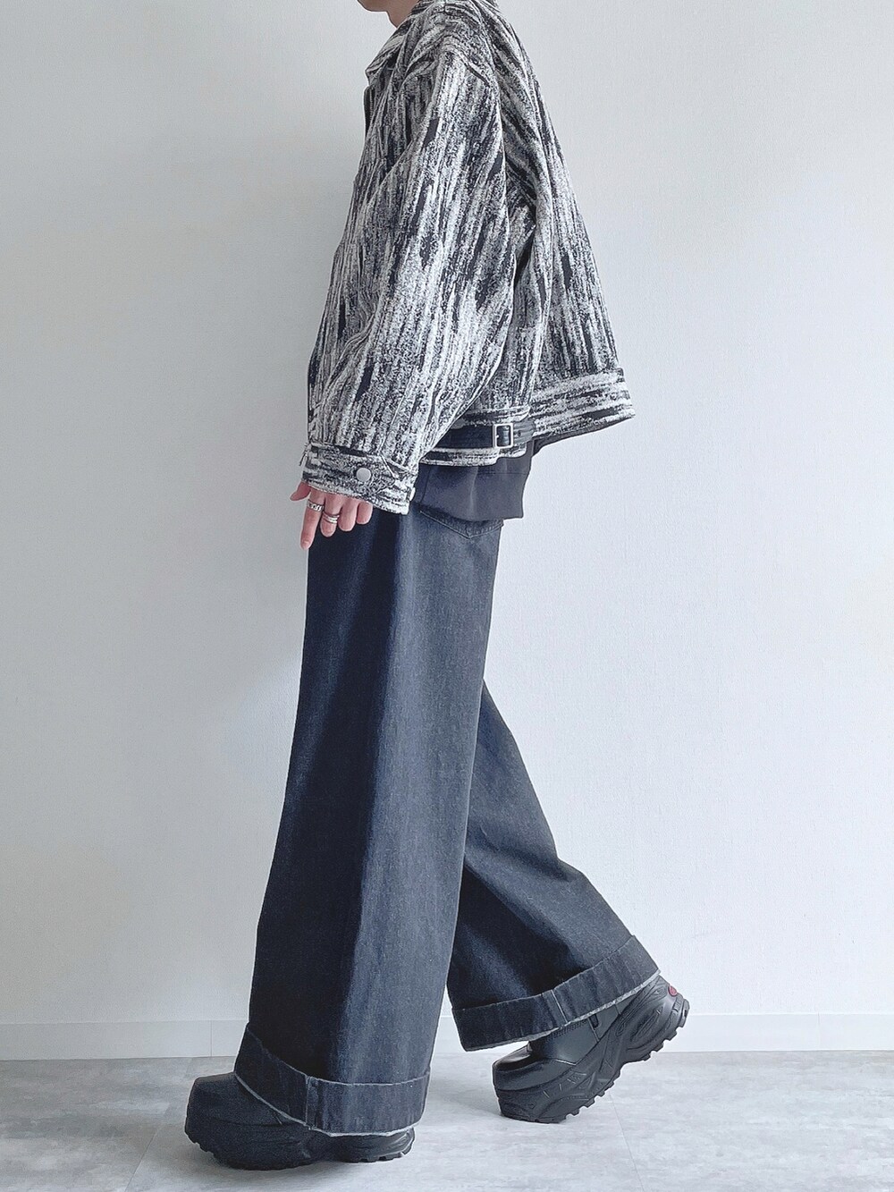 ホワイト系のブルゾン、ブラック系のトップス、ブラック系のデニムパンツを着用したメンズの冬コーディネートの2枚目の写真