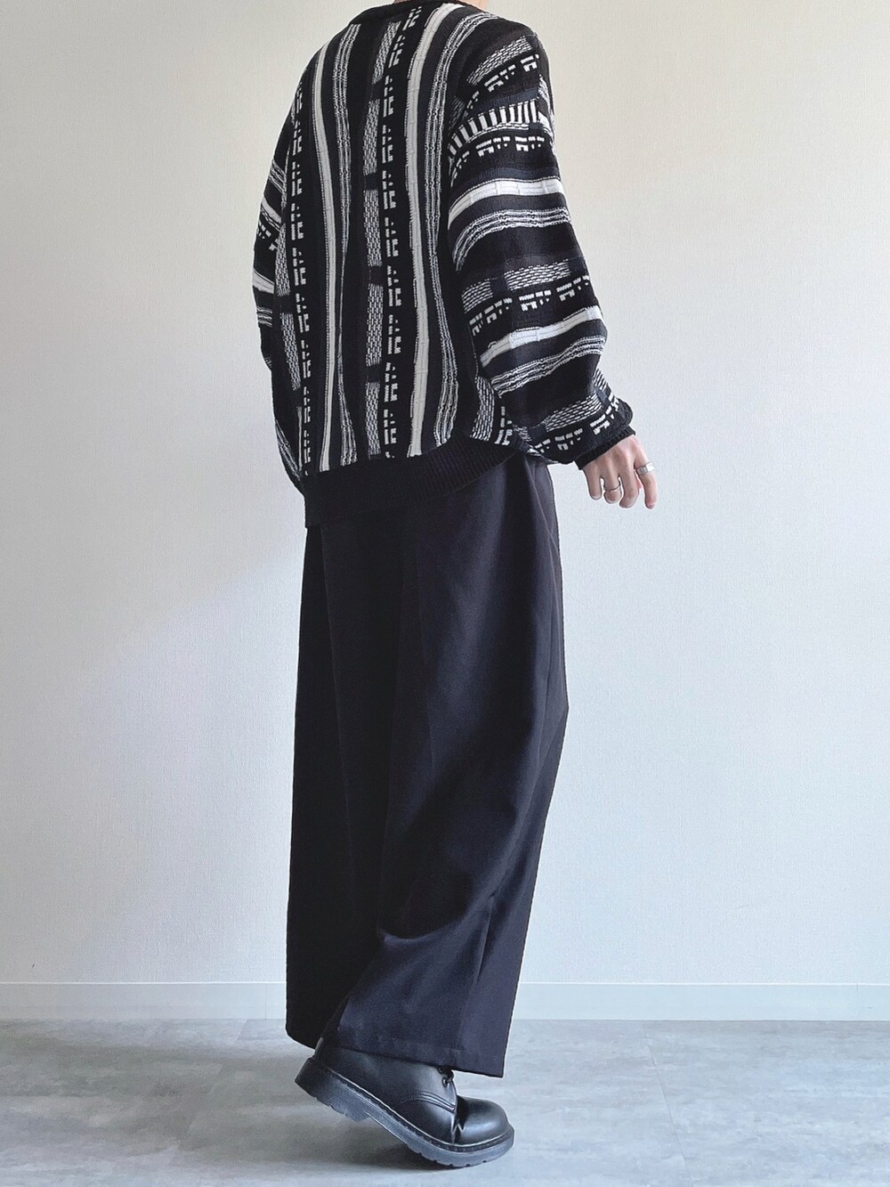 ブラック系のニット/セーター、ブラック系のスラックス、ブラック系のシューズを着用したメンズの冬コーディネートの4枚目の写真