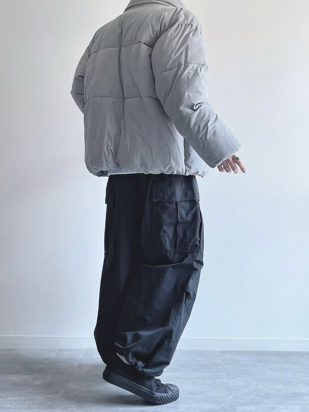 グレー系のダウンジャケット/コート、ホワイト系のトップス、ブラック系のカーゴパンツを着用したメンズの冬コーディネートの4枚目の写真