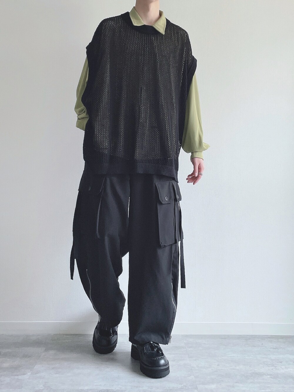 グリーン系のシャツ/ブラウス、ブラック系のベスト、ブラック系のカーゴパンツを着用したメンズの春コーディネートの4枚目の写真