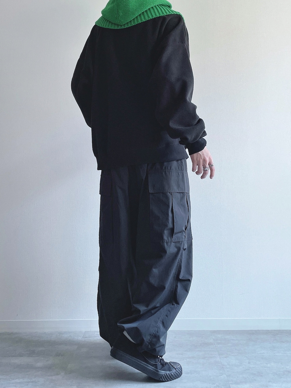 ブラック系のスウェット、ブラック系のカーゴパンツ、ブラック系のスニーカーを着用したメンズの冬コーディネートの3枚目の写真