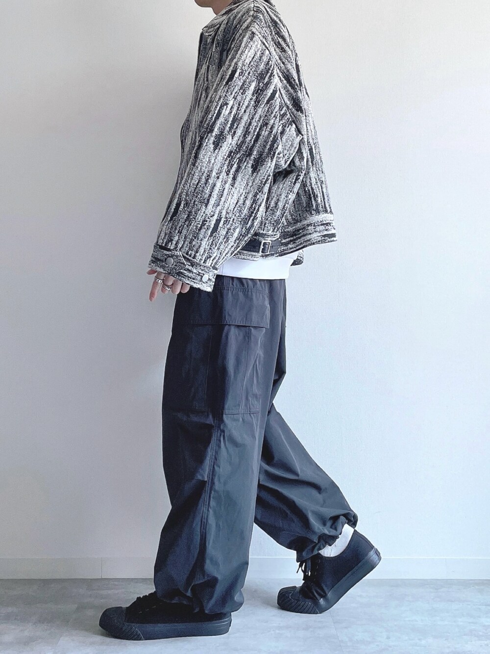 ホワイト系のブルゾン、ホワイト系のトップス、ブラック系のカーゴパンツを着用したメンズの冬コーディネートの3枚目の写真