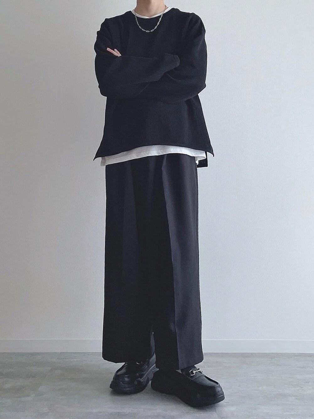 ブラック系のトップス、ブラック系のスラックス、ブラック系のスニーカーを着用したメンズの秋コーディネートの5枚目の写真