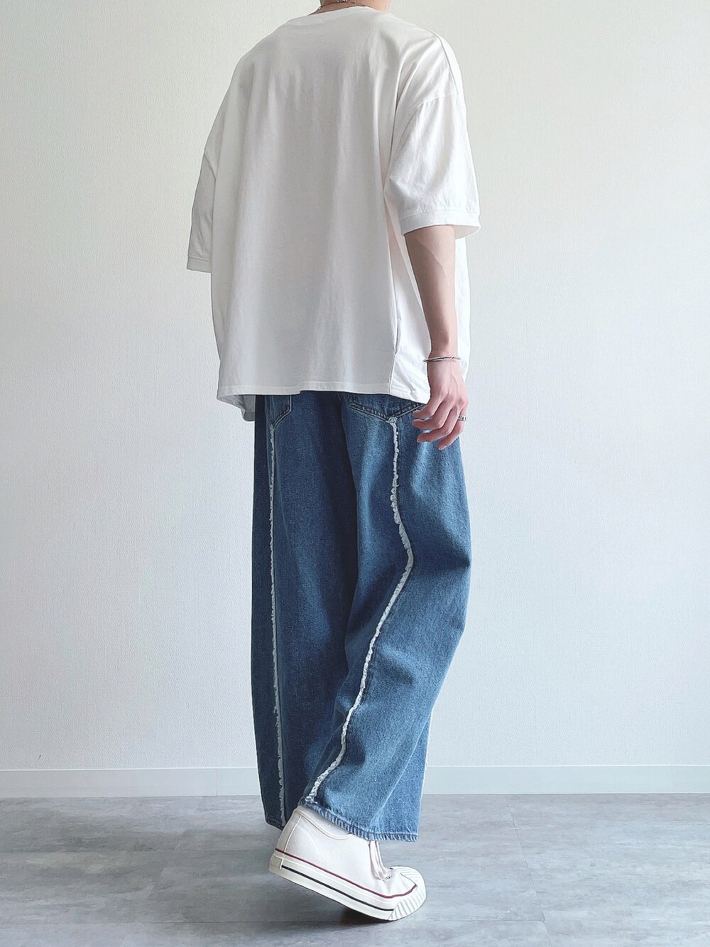 ホワイト系のTシャツ/カットソー、ブルー系のデニムパンツ、ホワイト系のスニーカーを着用したメンズの春コーディネートの4枚目の写真