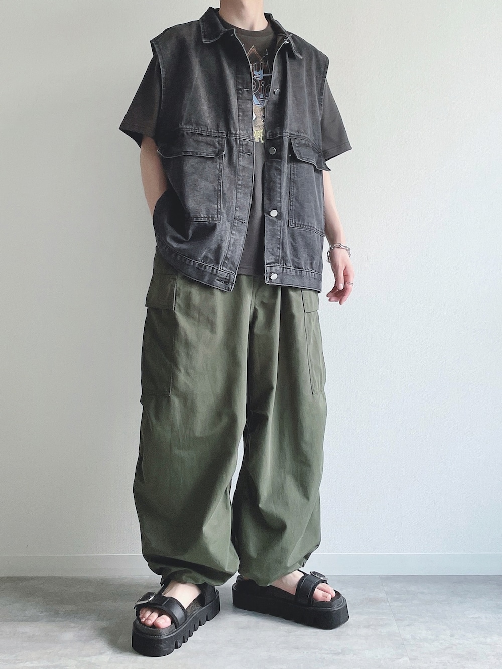 ブラック系のベスト、ブラック系のTシャツ/カットソー、グリーン系のカーゴパンツを着用したメンズの夏コーディネートの3枚目の写真