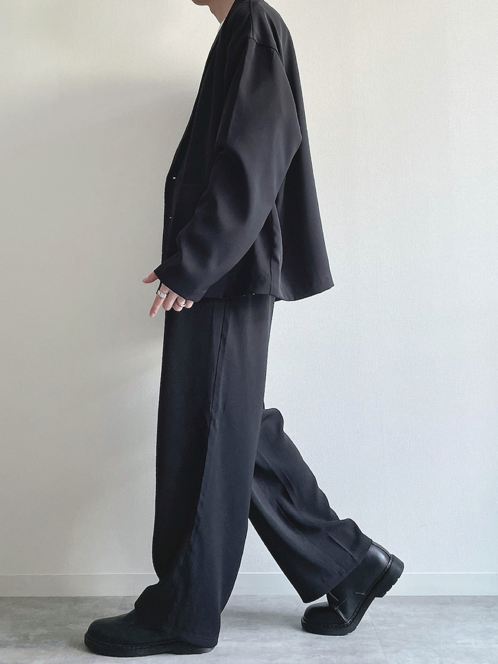 ブラック系のセットアップ、ホワイト系のTシャツ/カットソー、ブラック系のシューズを着用したメンズの春コーディネートの3枚目の写真