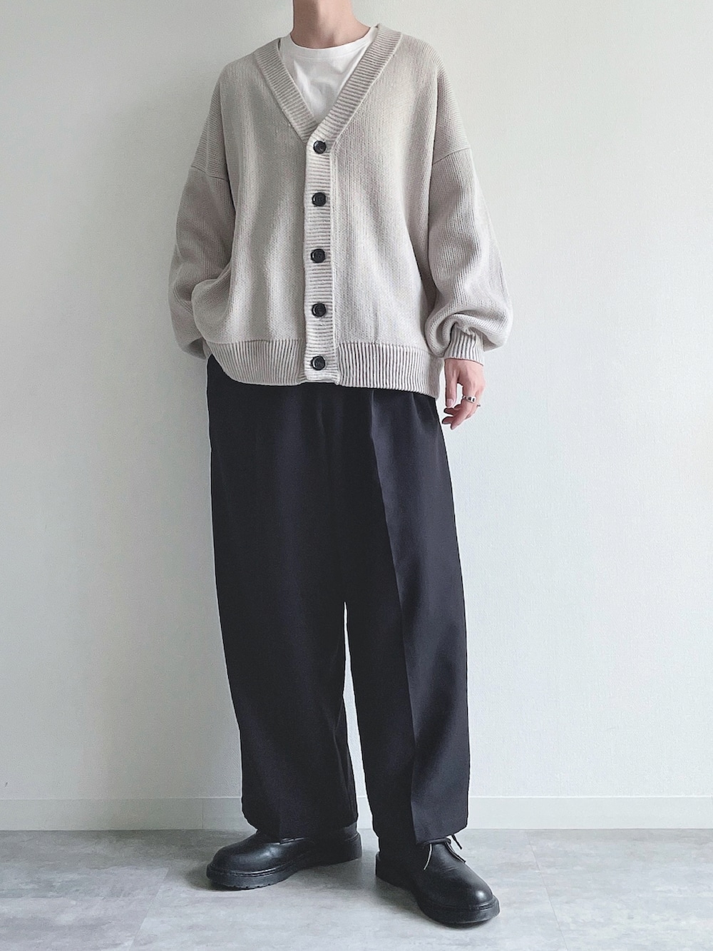 グレー系のカーディガン/ボレロ、ホワイト系のTシャツ/カットソー、ブラック系のスラックスを着用したメンズの秋コーディネートの2枚目の写真