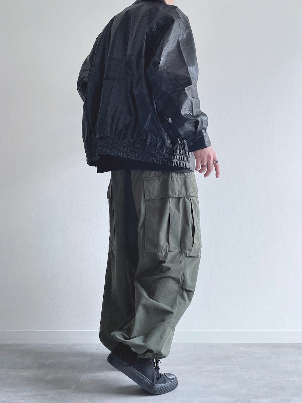 ブラック系のブルゾン、ブラック系のスウェット、グリーン系のカーゴパンツを着用したメンズの冬コーディネートの4枚目の写真