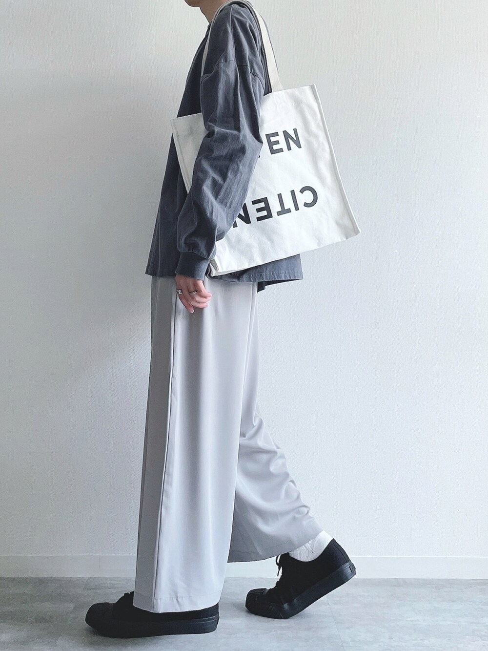 ブルー系のTシャツ/カットソー、グレー系のスラックス、ブラック系のスニーカーを着用したメンズの秋コーディネートの3枚目の写真