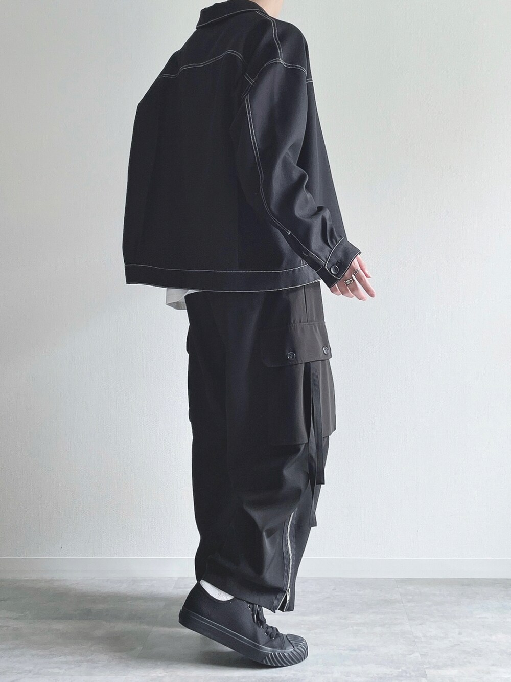 ブラック系のブルゾン、ホワイト系のTシャツ/カットソー、ブラック系のカーゴパンツを着用したメンズの秋コーディネートの4枚目の写真