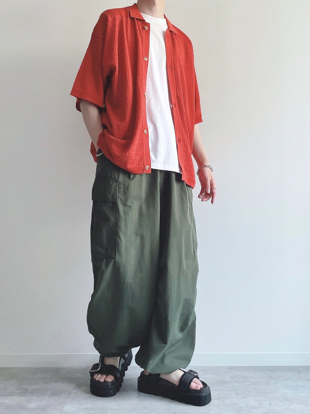 オレンジ系のシャツ/ブラウス、ホワイト系のTシャツ/カットソー、グリーン系のカーゴパンツを着用したメンズの夏コーディネートの4枚目の写真