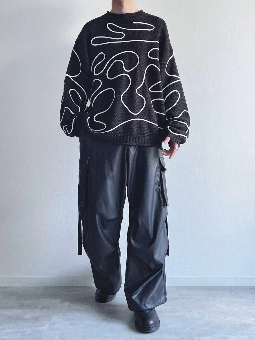 ブラック系のニット/セーター、ブラック系のカーゴパンツ、ブラック系のシューズを着用したメンズの冬コーディネートの3枚目の写真