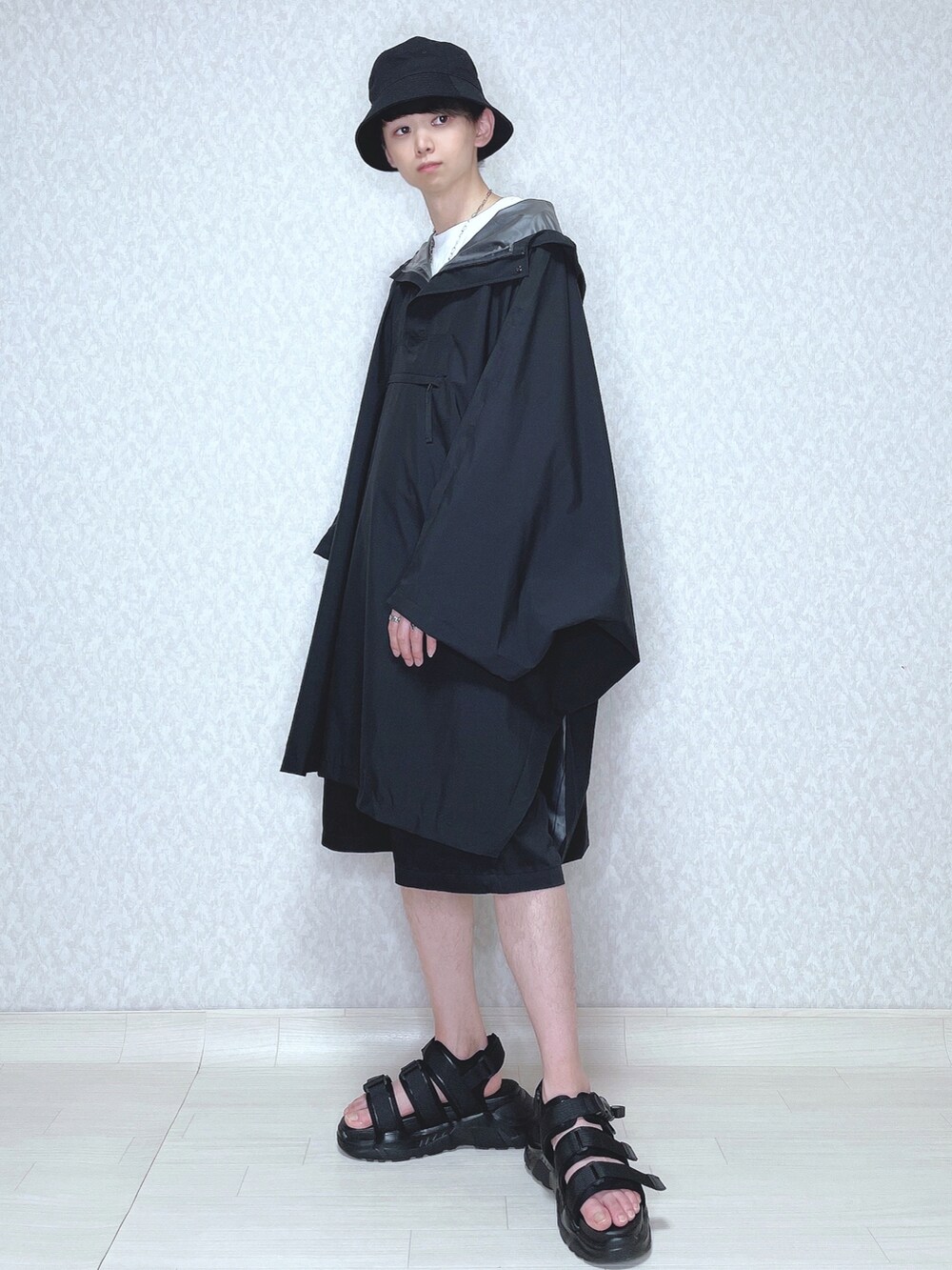 ブラック系のトップス、ホワイト系のTシャツ/カットソー、ブラック系のチノパンツを着用したメンズの春コーディネートの2枚目の写真