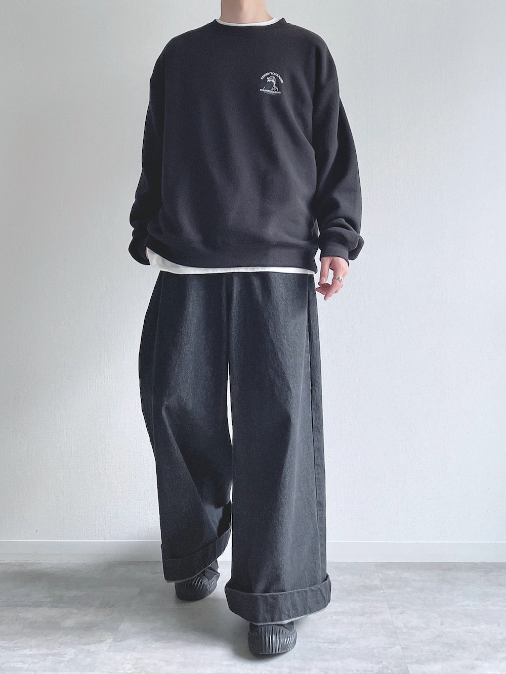 ブラック系のスウェット、ホワイト系のTシャツ/カットソー、ブラック系のデニムパンツを着用したメンズの冬コーディネートの2枚目の写真