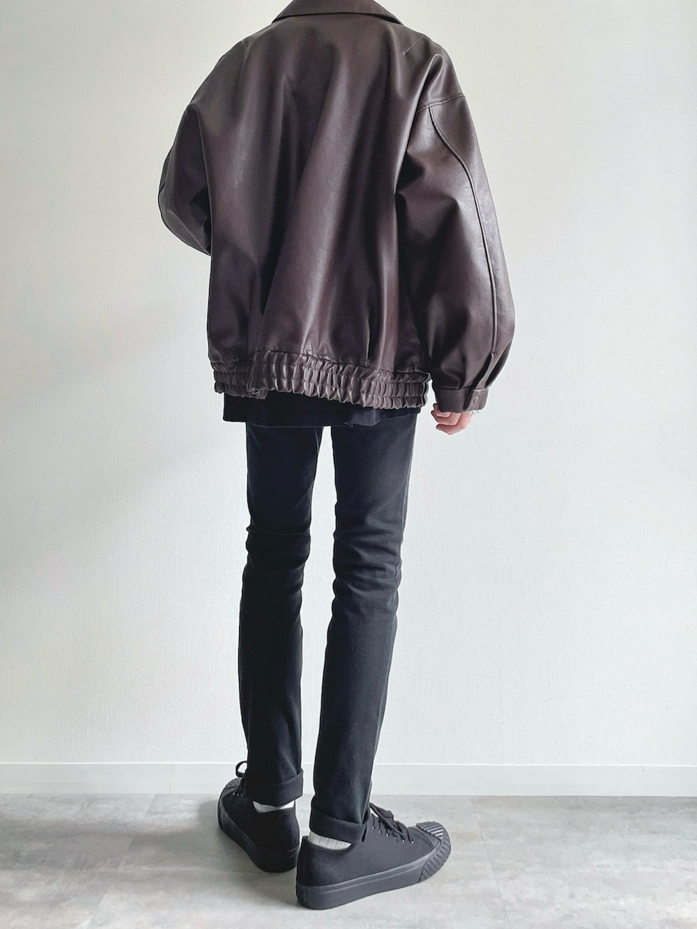 ブラウン系のブルゾン、ブラック系のTシャツ/カットソー、ブラック系のパンツを着用したメンズの冬コーディネートの4枚目の写真