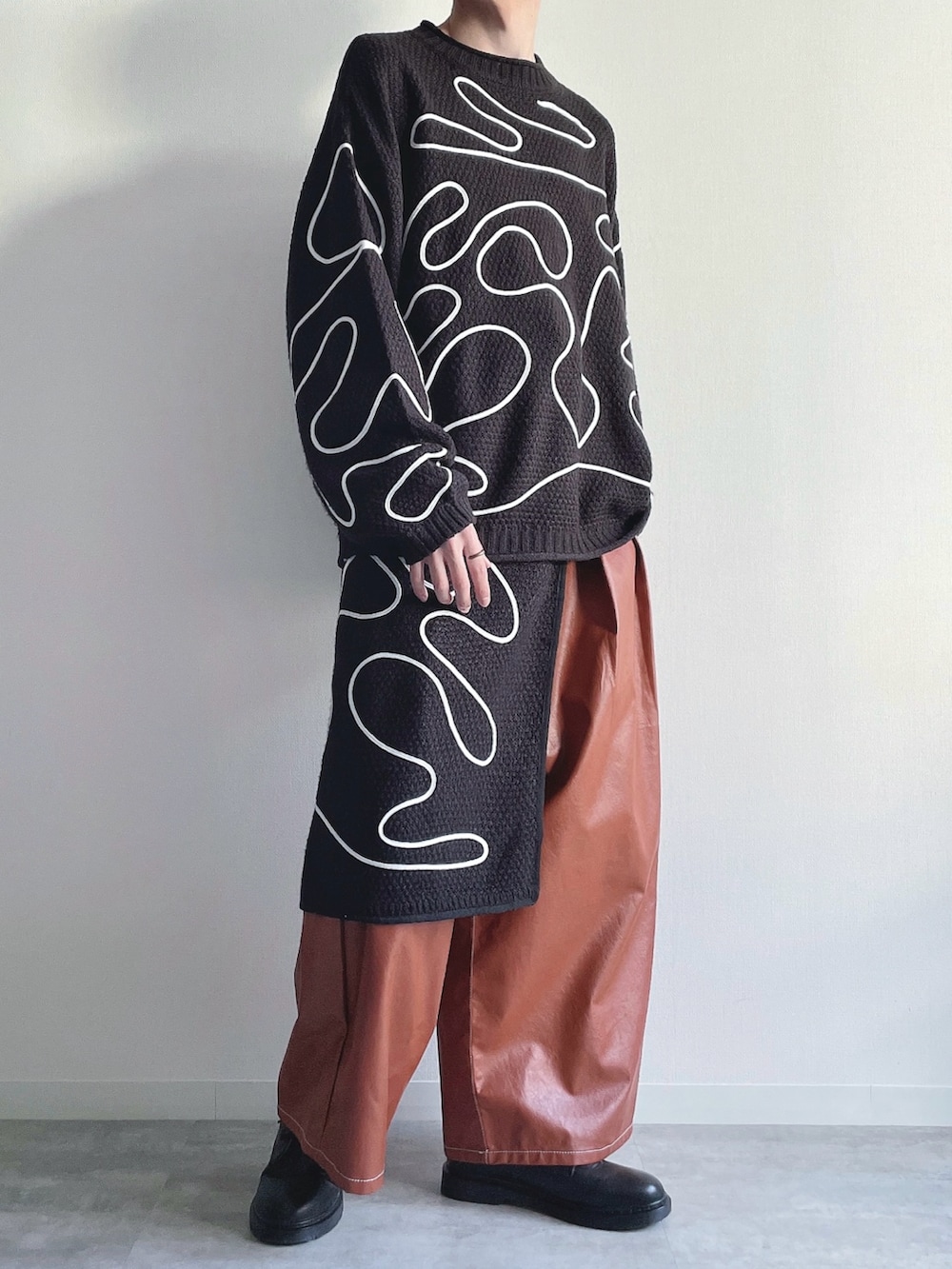 ブラック系のニット/セーター、ブラック系のスカート、ブラウン系のその他パンツを着用したメンズの冬コーディネートの4枚目の写真