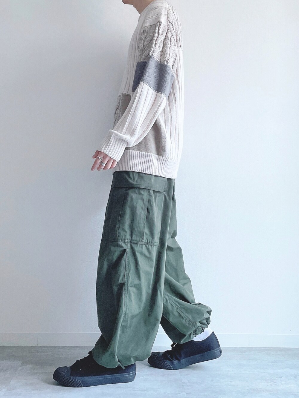 ホワイト系のニット/セーター、グリーン系のカーゴパンツ、ブラック系のスニーカーを着用したメンズの冬コーディネートの3枚目の写真