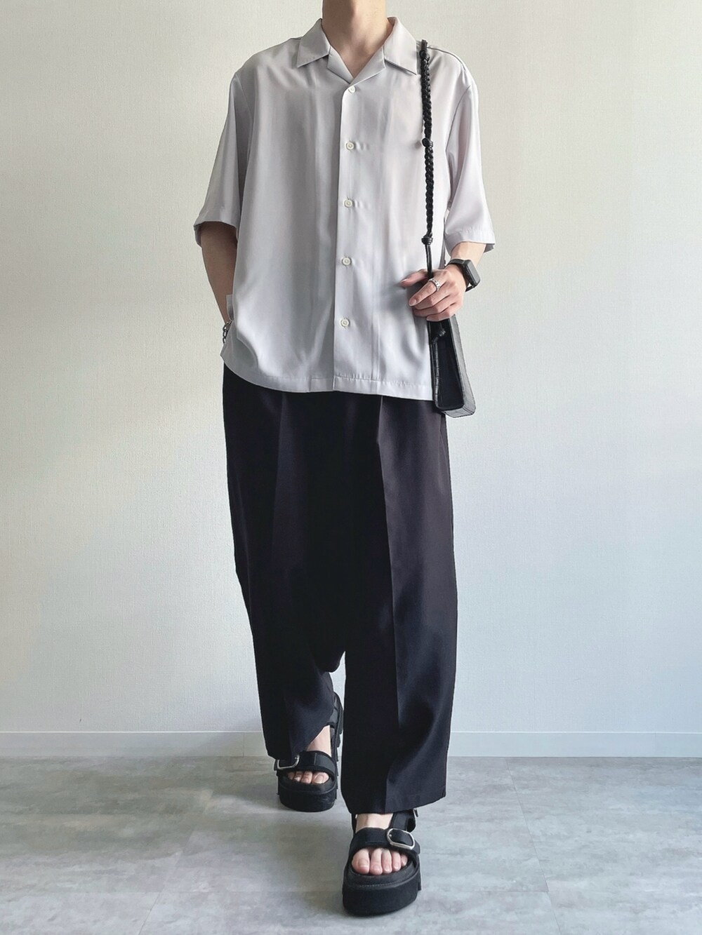 グレー系のトップス、ホワイト系のタンクトップ、ブラック系のスラックスを着用したメンズの夏コーディネートの2枚目の写真