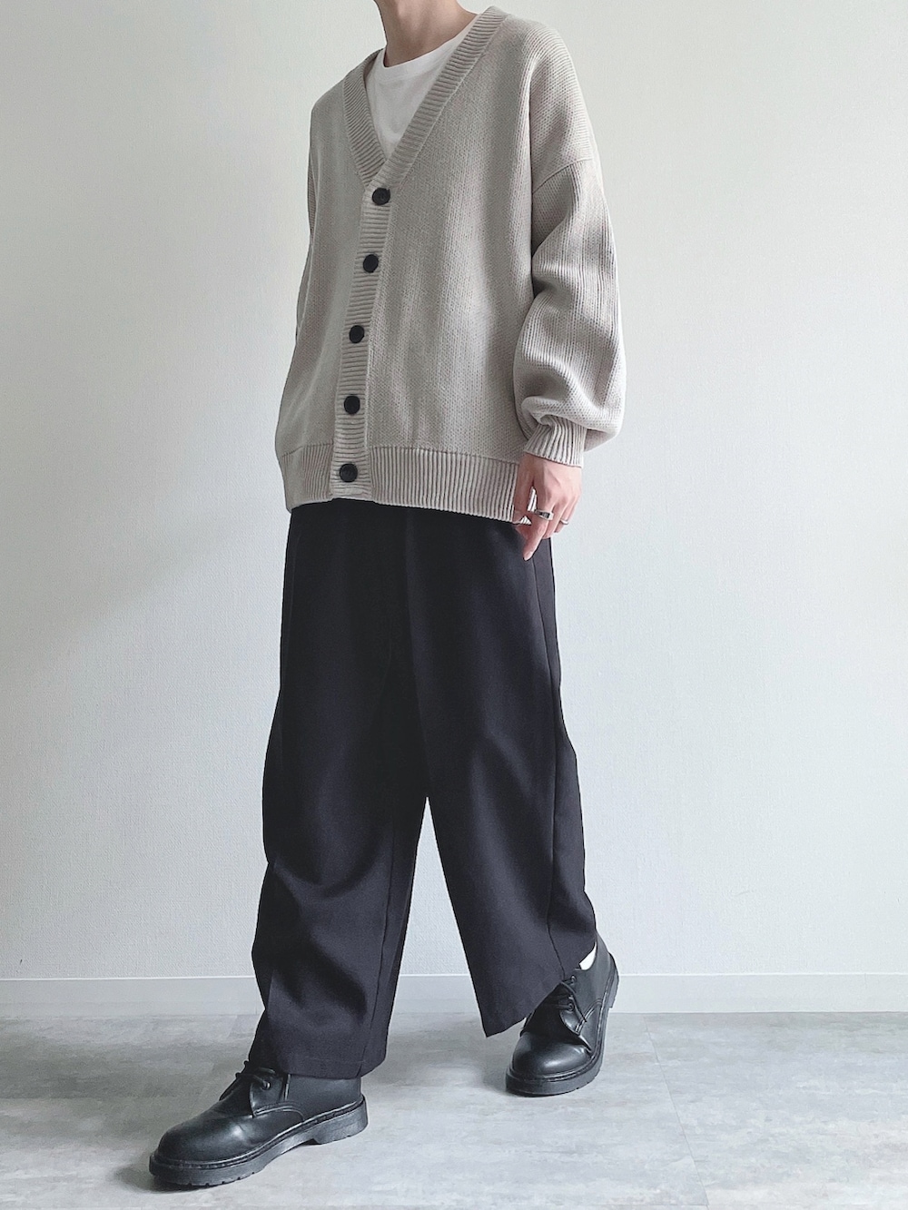 グレー系のカーディガン/ボレロ、ホワイト系のTシャツ/カットソー、ブラック系のスラックスを着用したメンズの秋コーディネートの5枚目の写真