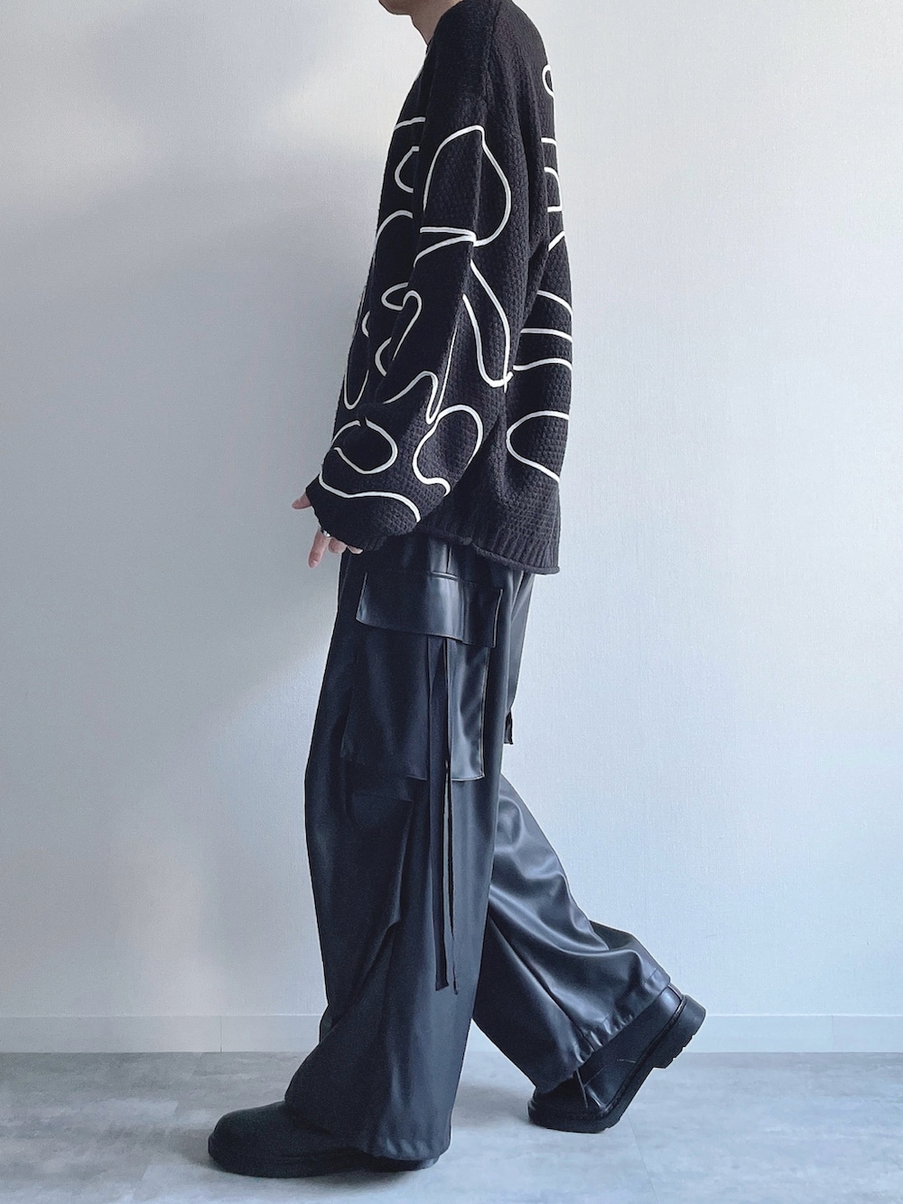 ブラック系のニット/セーター、ブラック系のカーゴパンツ、ブラック系のシューズを着用したメンズの冬コーディネートの2枚目の写真