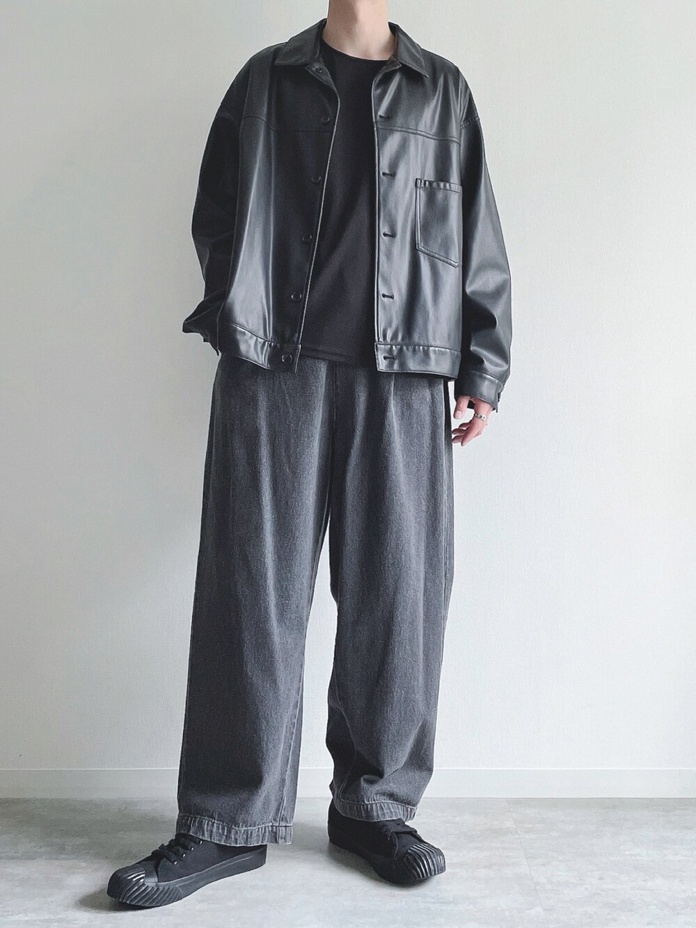 ブラック系のブルゾン、ブラック系のTシャツ/カットソー、ブラック系のデニムパンツを着用したメンズの秋コーディネートの5枚目の写真