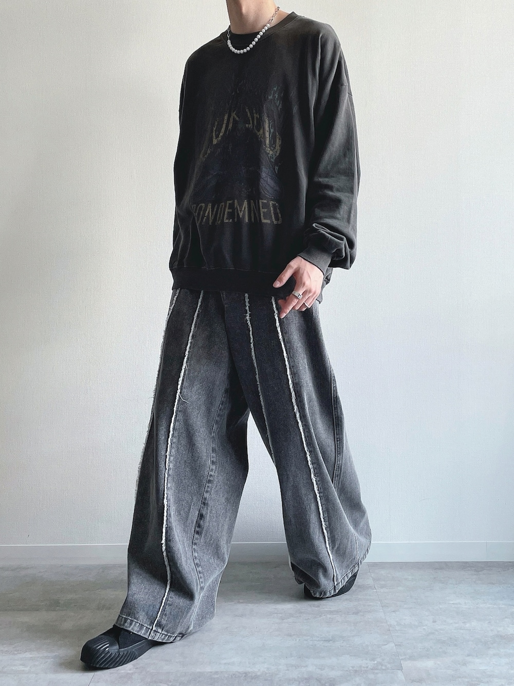 グレー系のスウェット、グレー系のデニムパンツ、ブラック系のスニーカーを着用したメンズの春コーディネートの5枚目の写真