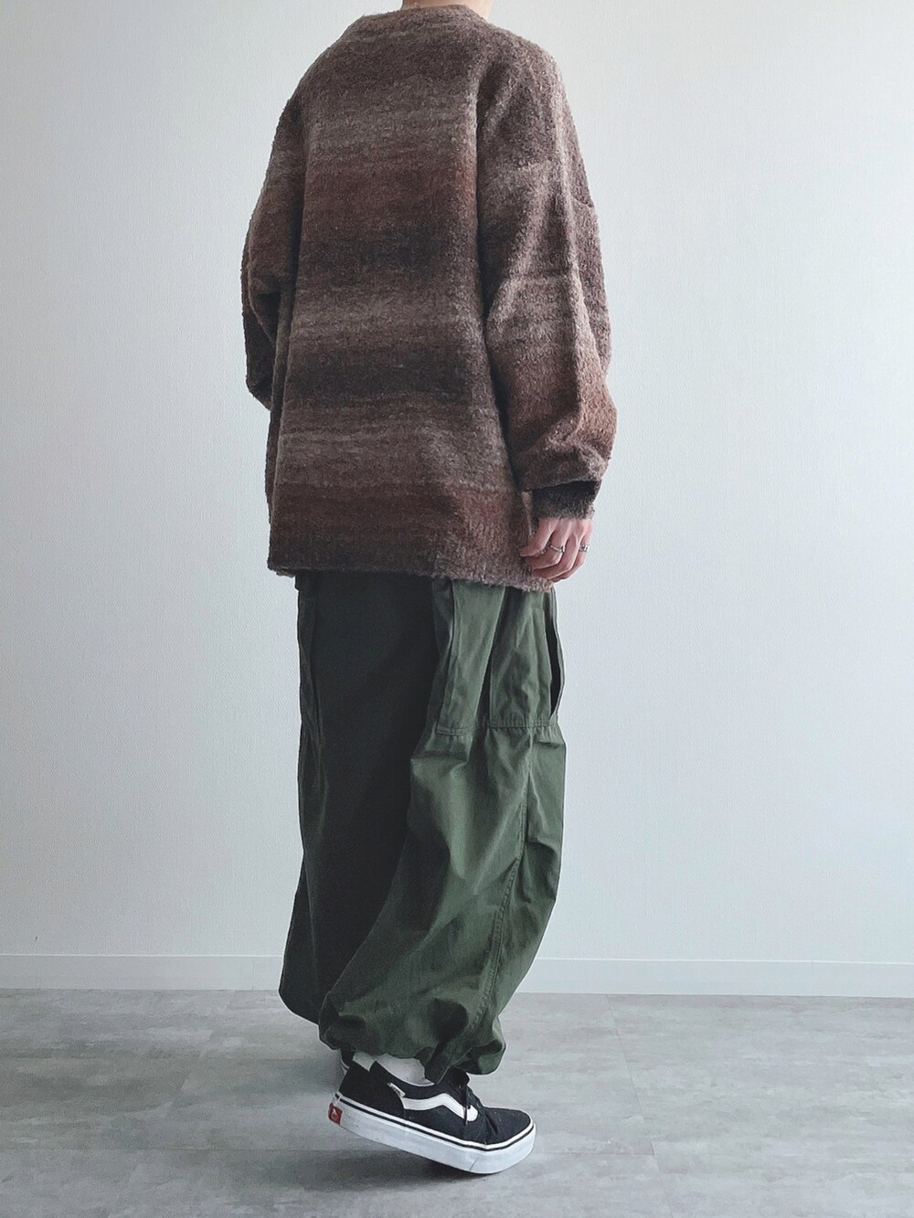 ブラウン系のニット/セーター、グリーン系のカーゴパンツ、ブラック系のスニーカーを着用したメンズの秋コーディネートの3枚目の写真