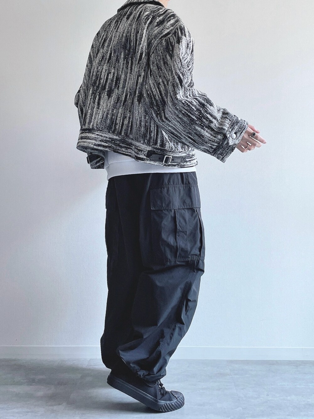 ホワイト系のブルゾン、ホワイト系のトップス、ブラック系のカーゴパンツを着用したメンズの冬コーディネートの4枚目の写真