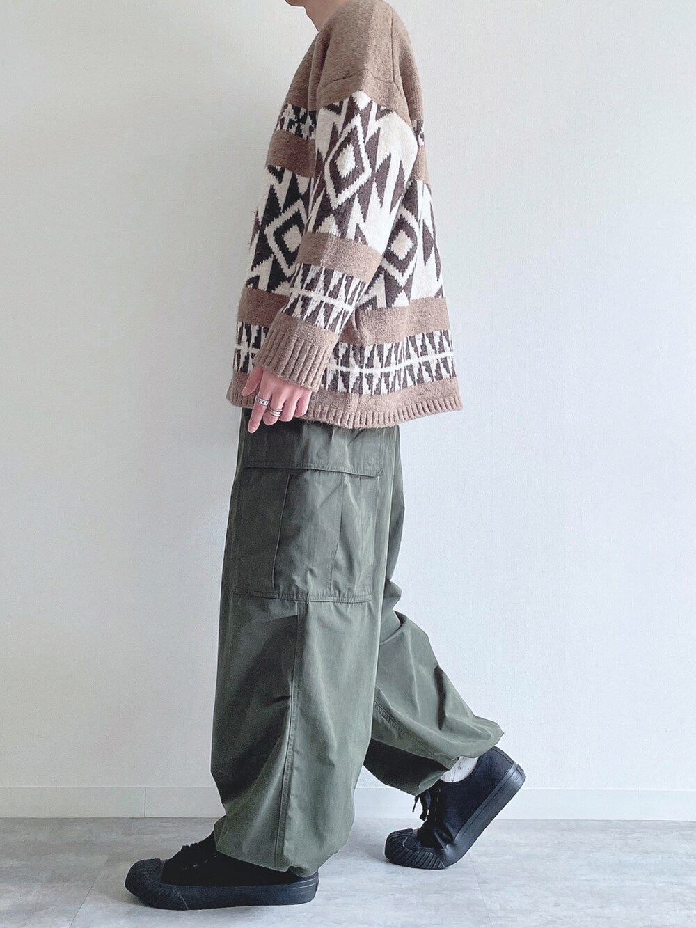 ベージュ系のカーディガン/ボレロ、ブラック系のスウェット、グリーン系のカーゴパンツを着用したメンズの冬コーディネートの3枚目の写真