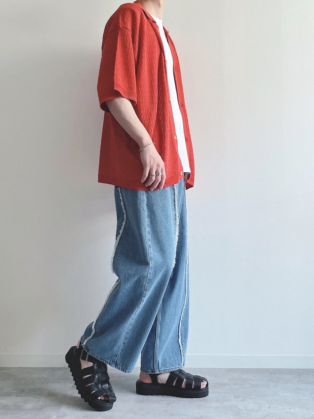 オレンジ系のシャツ/ブラウス、ホワイト系のタンクトップ、ブルー系のデニムパンツを着用したメンズの夏コーディネートの2枚目の写真