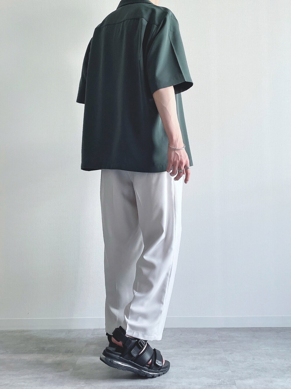 グリーン系のトップス、ブラック系のTシャツ/カットソー、ホワイト系のスラックスを着用したメンズの夏コーディネートの4枚目の写真