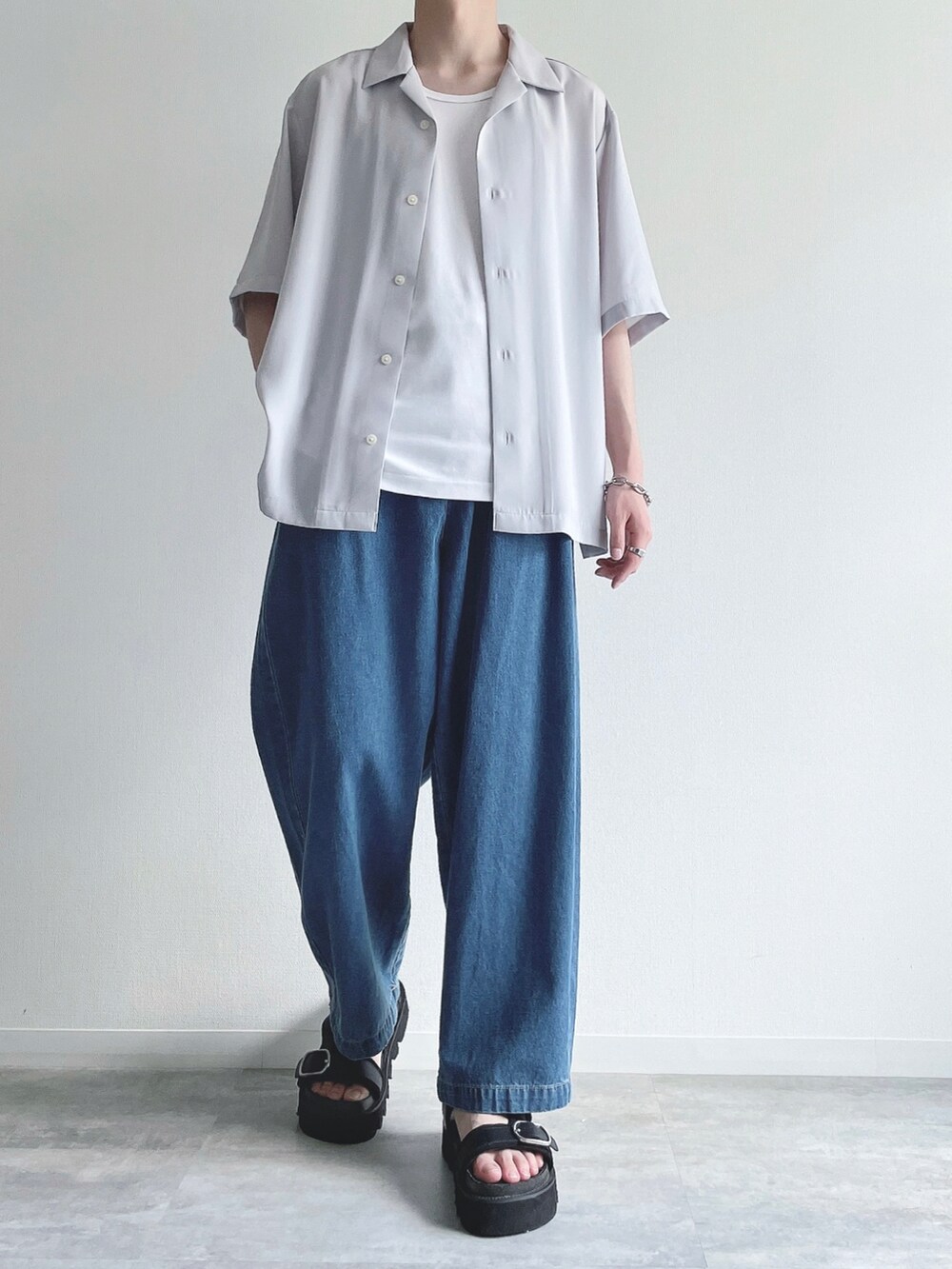 グレー系のトップス、ホワイト系のタンクトップ、ブルー系のデニムパンツを着用したメンズの夏コーディネートの2枚目の写真