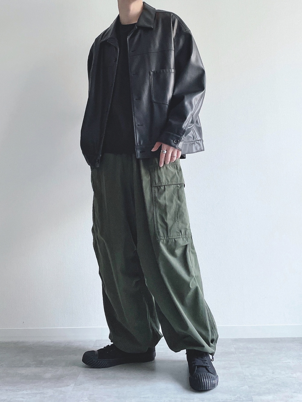 ブラック系のブルゾン、ブラック系のTシャツ/カットソー、グリーン系のカーゴパンツを着用したメンズの秋コーディネートの5枚目の写真