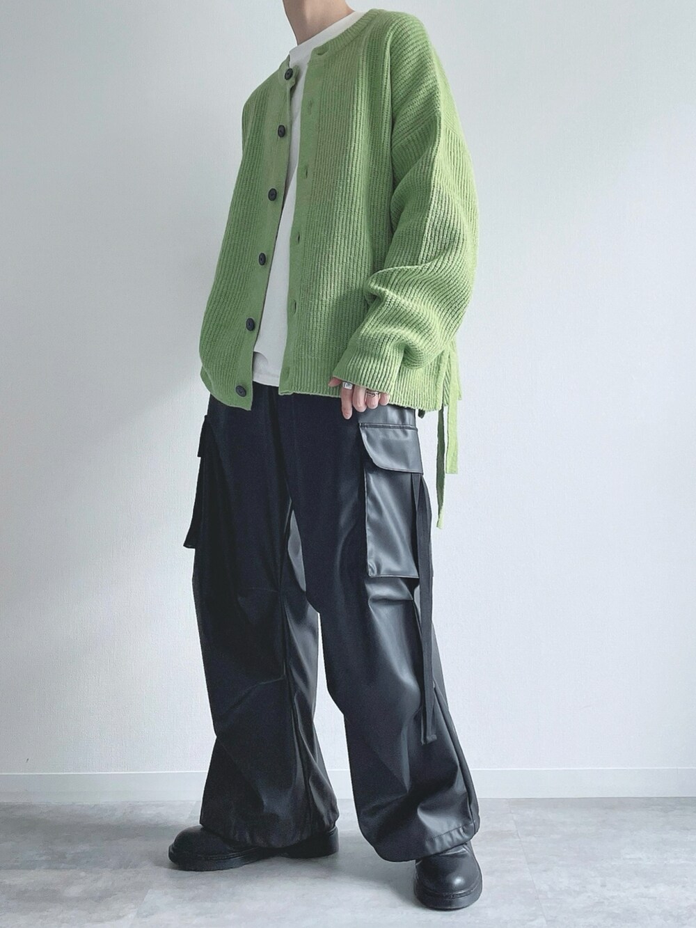 グリーン系のカーディガン/ボレロ、ホワイト系のTシャツ/カットソー、ブラック系のカーゴパンツを着用したメンズの秋コーディネートの5枚目の写真
