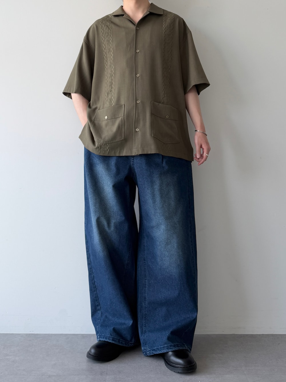 グリーン系のシャツ/ブラウス、ブルー系のデニムパンツ、ブラック系のシューズを着用したメンズの春コーディネートの5枚目の写真