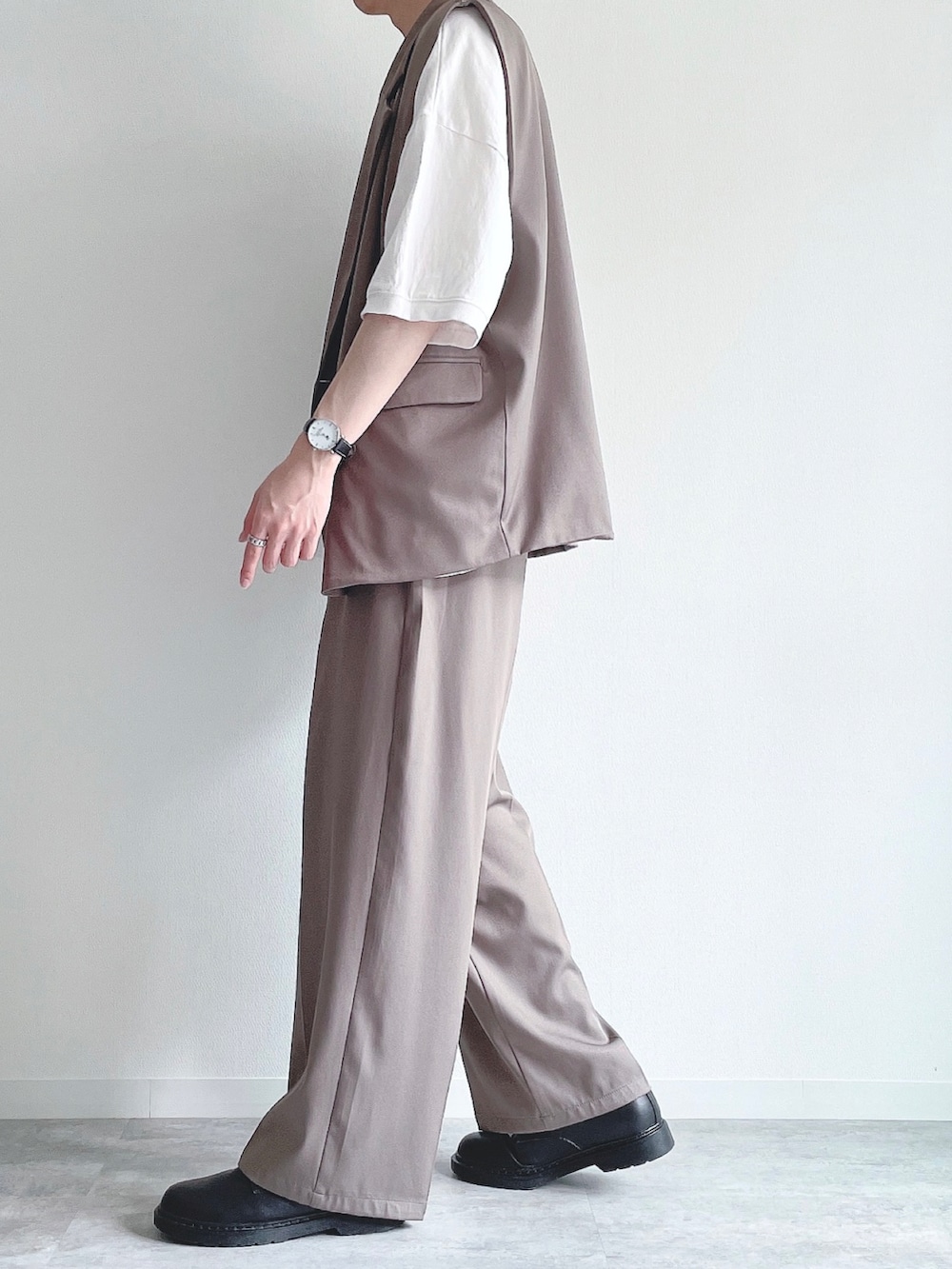 ベージュ系のベスト、ホワイト系のTシャツ/カットソー、ベージュ系のスラックスを着用したメンズの夏コーディネートの3枚目の写真