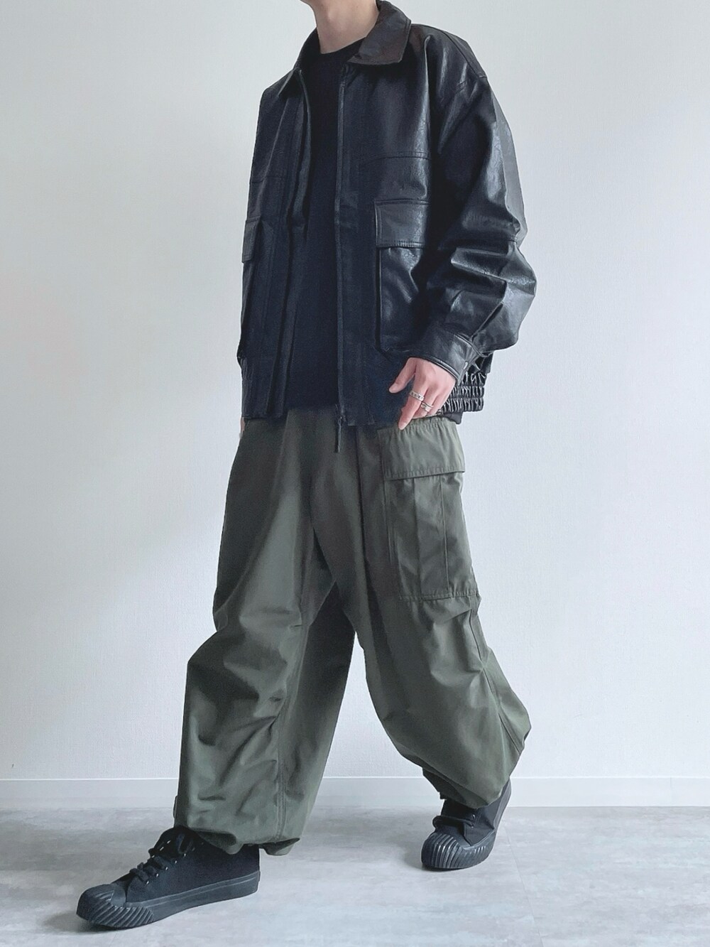 ブラック系のブルゾン、ブラック系のスウェット、グリーン系のカーゴパンツを着用したメンズの冬コーディネートの5枚目の写真