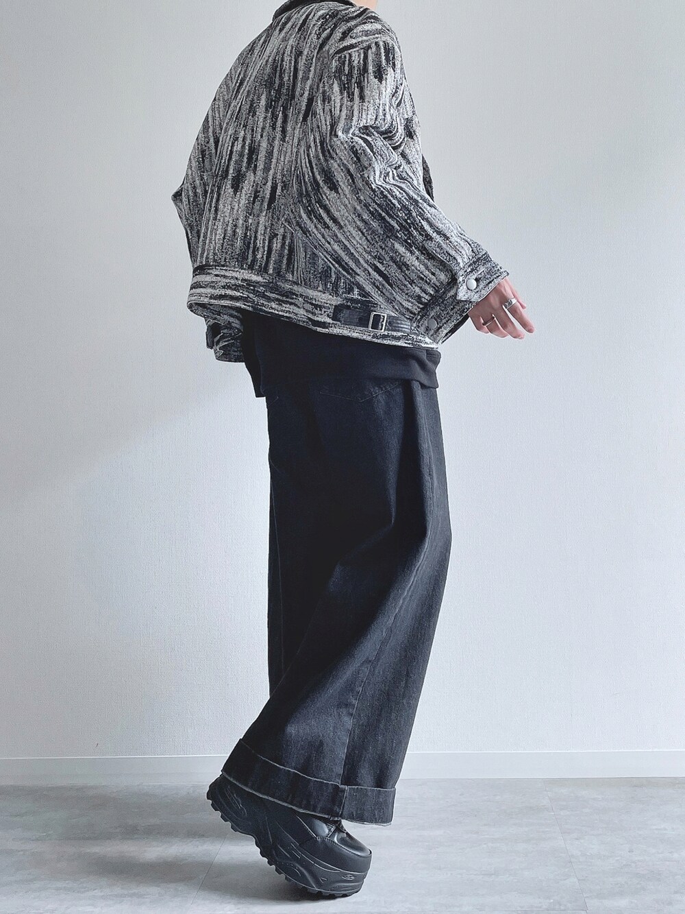 ホワイト系のブルゾン、ブラック系のトップス、ブラック系のデニムパンツを着用したメンズの冬コーディネートの3枚目の写真