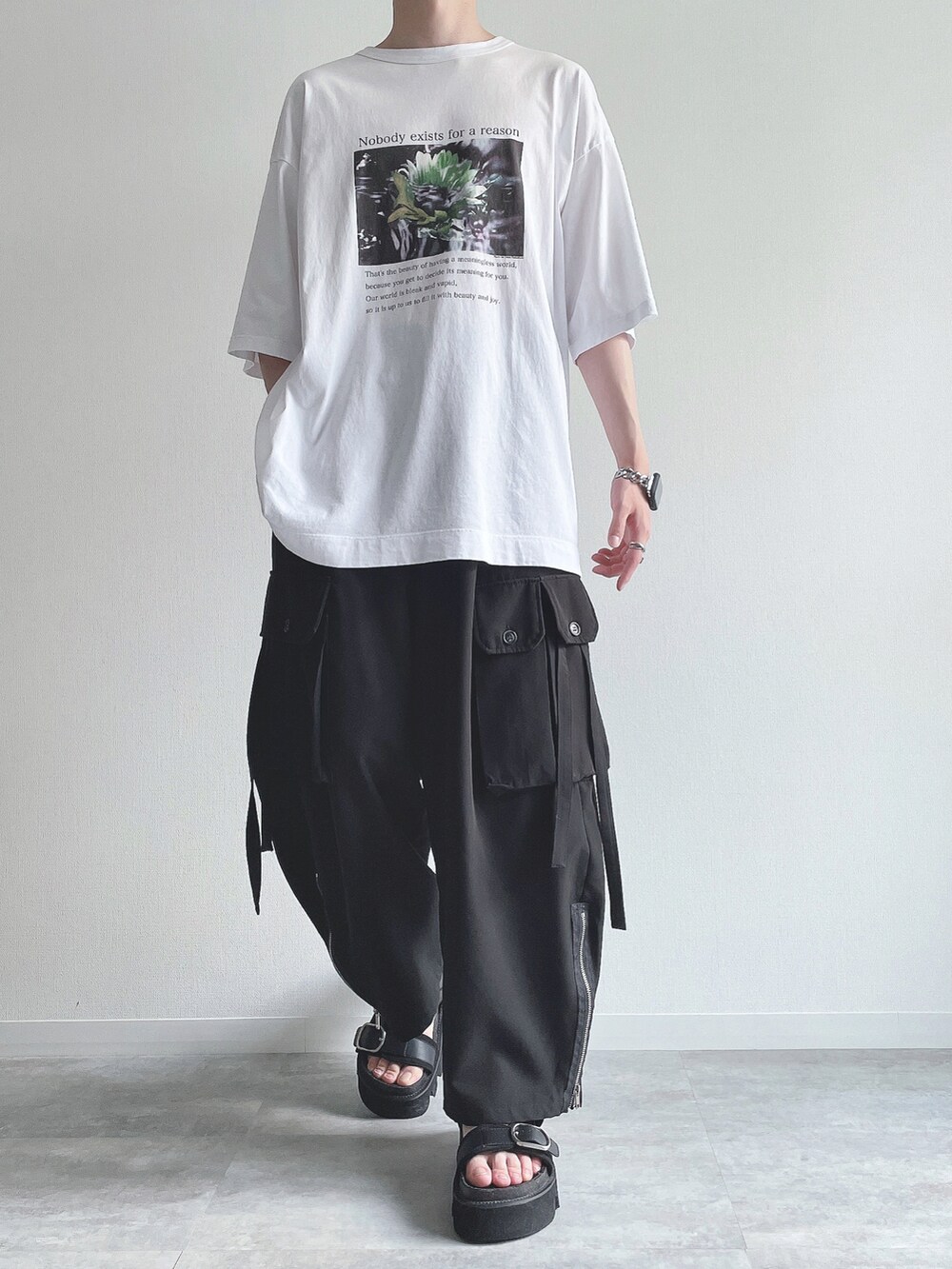 ホワイト系のTシャツ/カットソー、ブラック系のカーゴパンツ、ブラック系のサンダルを着用したメンズの夏コーディネートの2枚目の写真