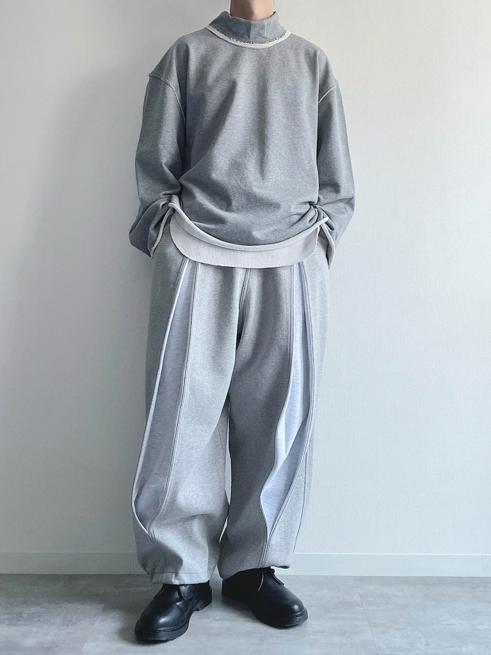 グレー系のスウェット、ホワイト系のTシャツ/カットソー、グレー系のパンツを着用したメンズの冬コーディネートの2枚目の写真