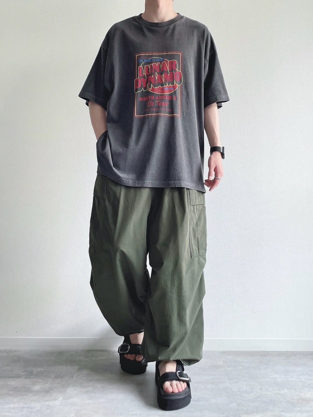 グレー系のTシャツ/カットソー、グリーン系のカーゴパンツ、ブラック系のサンダルを着用したメンズの夏コーディネートの2枚目の写真
