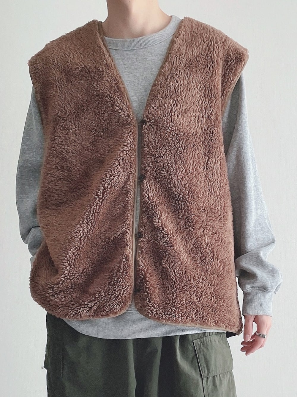 ブラウン系のベスト、グレー系のトップス、グリーン系のカーゴパンツを着用したメンズの秋コーディネートの4枚目の写真