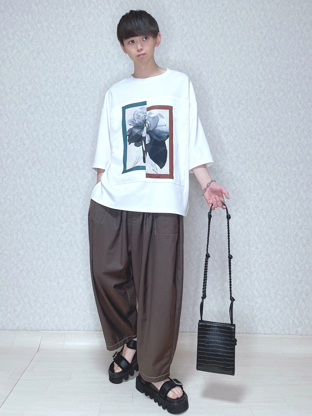 ホワイト系のTシャツ/カットソー、ブラウン系のその他パンツ、ブラック系のサンダルを着用したメンズの春コーディネートの2枚目の写真