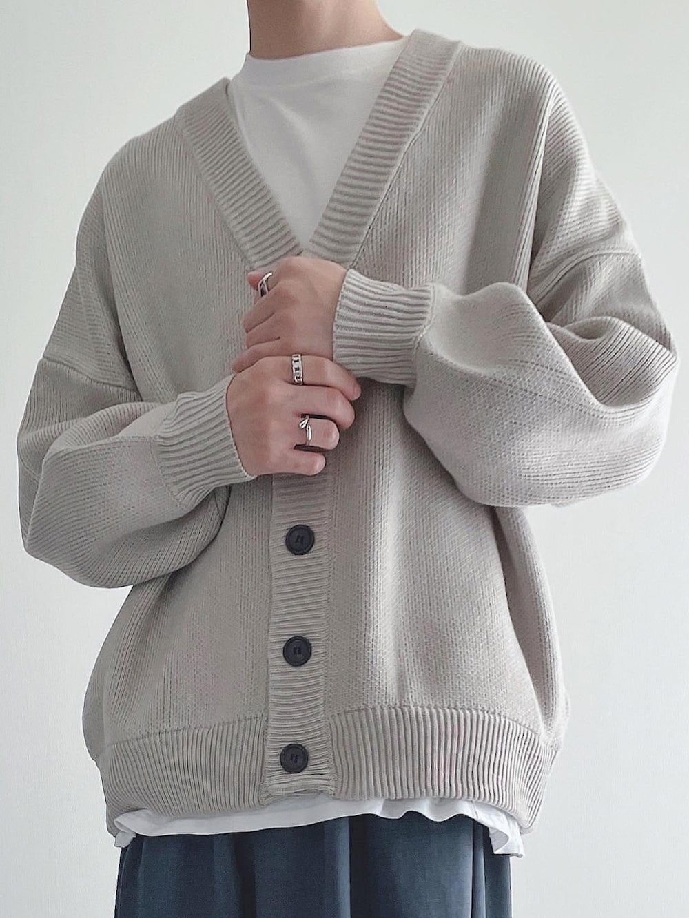 グレー系のカーディガン/ボレロ、ホワイト系のTシャツ/カットソー、ブルー系のスラックスを着用したメンズの秋コーディネートの3枚目の写真