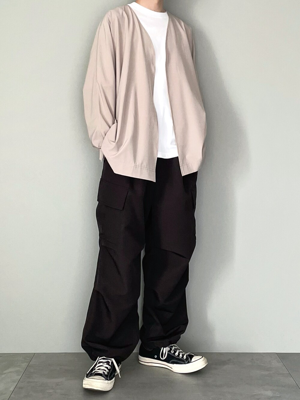 ベージュ系のカーディガン/ボレロ、ホワイト系のTシャツ/カットソー、ブラック系のカーゴパンツを着用したメンズの春コーディネートの5枚目の写真