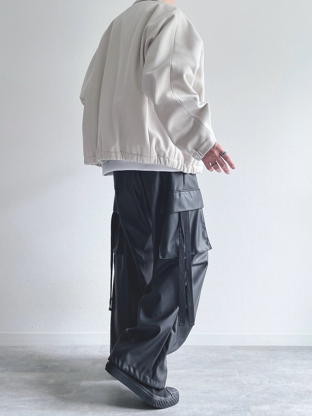 ホワイト系のブルゾン、ホワイト系のトップス、ブラック系のカーゴパンツを着用したメンズの冬コーディネートの4枚目の写真