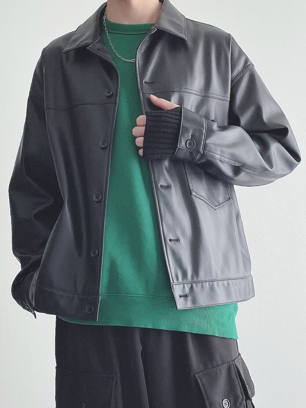 ブラック系のブルゾン、グリーン系のトップス、ブラック系のカーゴパンツを着用したメンズの秋コーディネートの4枚目の写真