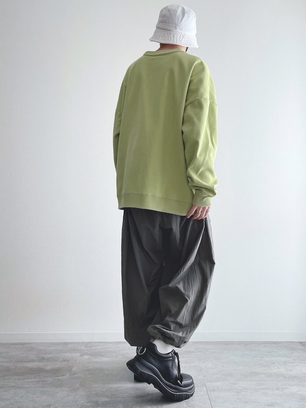 グリーン系のスウェット、グレー系のその他パンツ、ブラック系のスニーカーを着用したメンズの春コーディネートの3枚目の写真